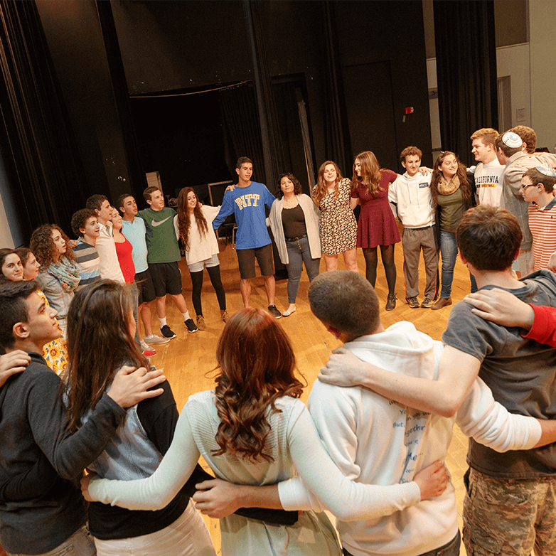 A group of teens standing in a circle.