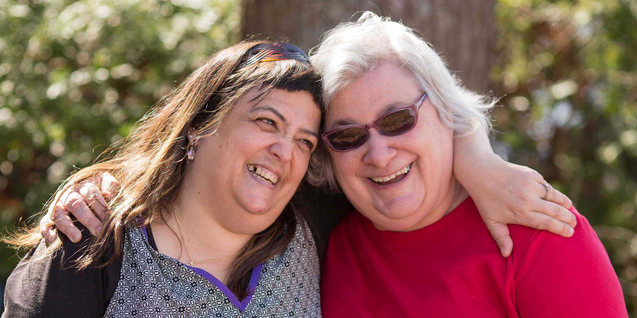 Two Women Hugging and Laughing|Jewish Residential Services Logo Two Women Hugging and Laughing|Jewish Residential Services Logo