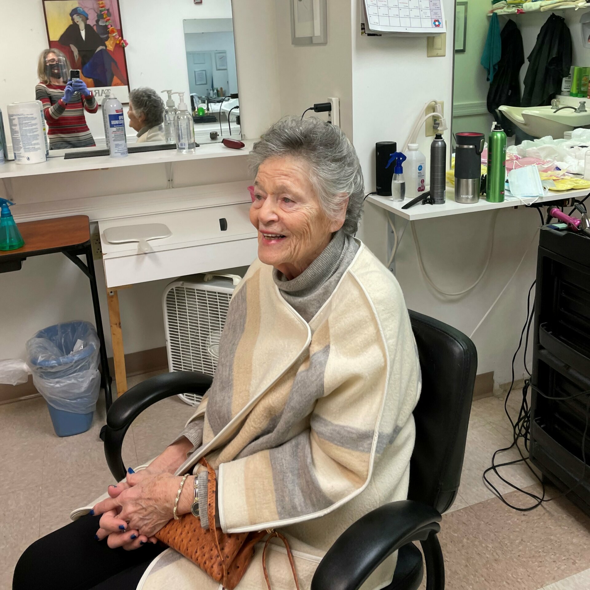 JAA resident Leanne poses with her new haircut. The hair stylist takes a photo in the mirror.