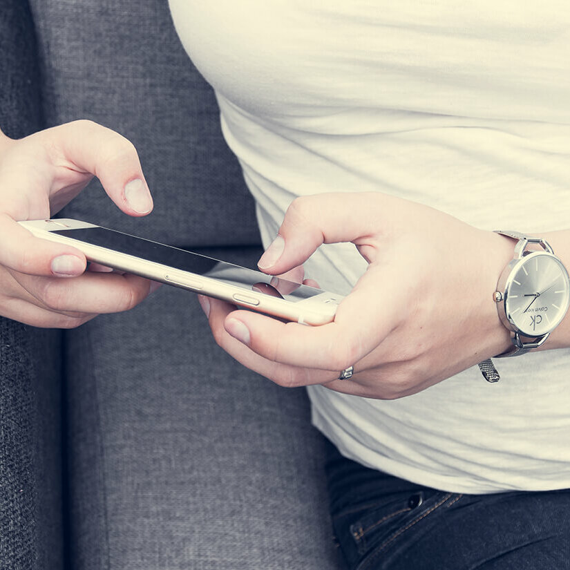 A closeup image of a person texting on their cellphone.