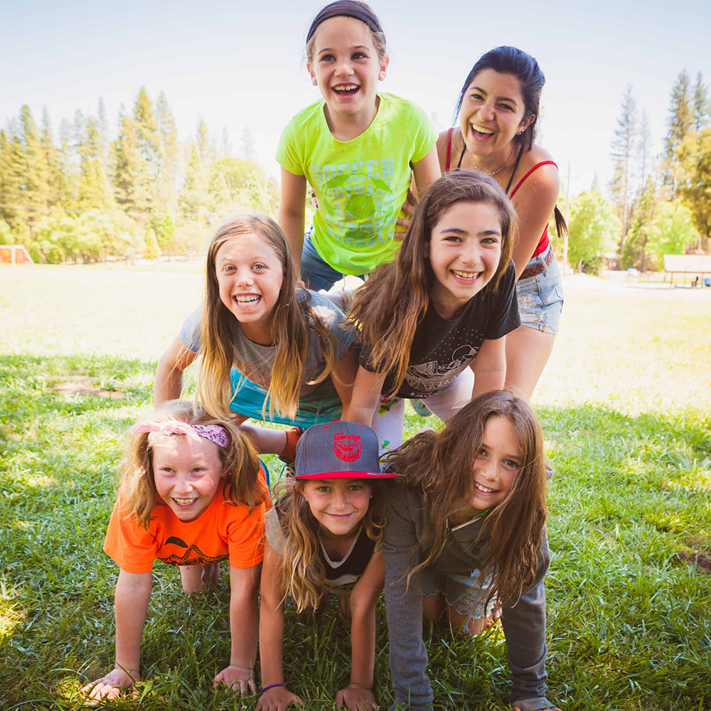 kids and counsellor at summer camp making a human pyramid