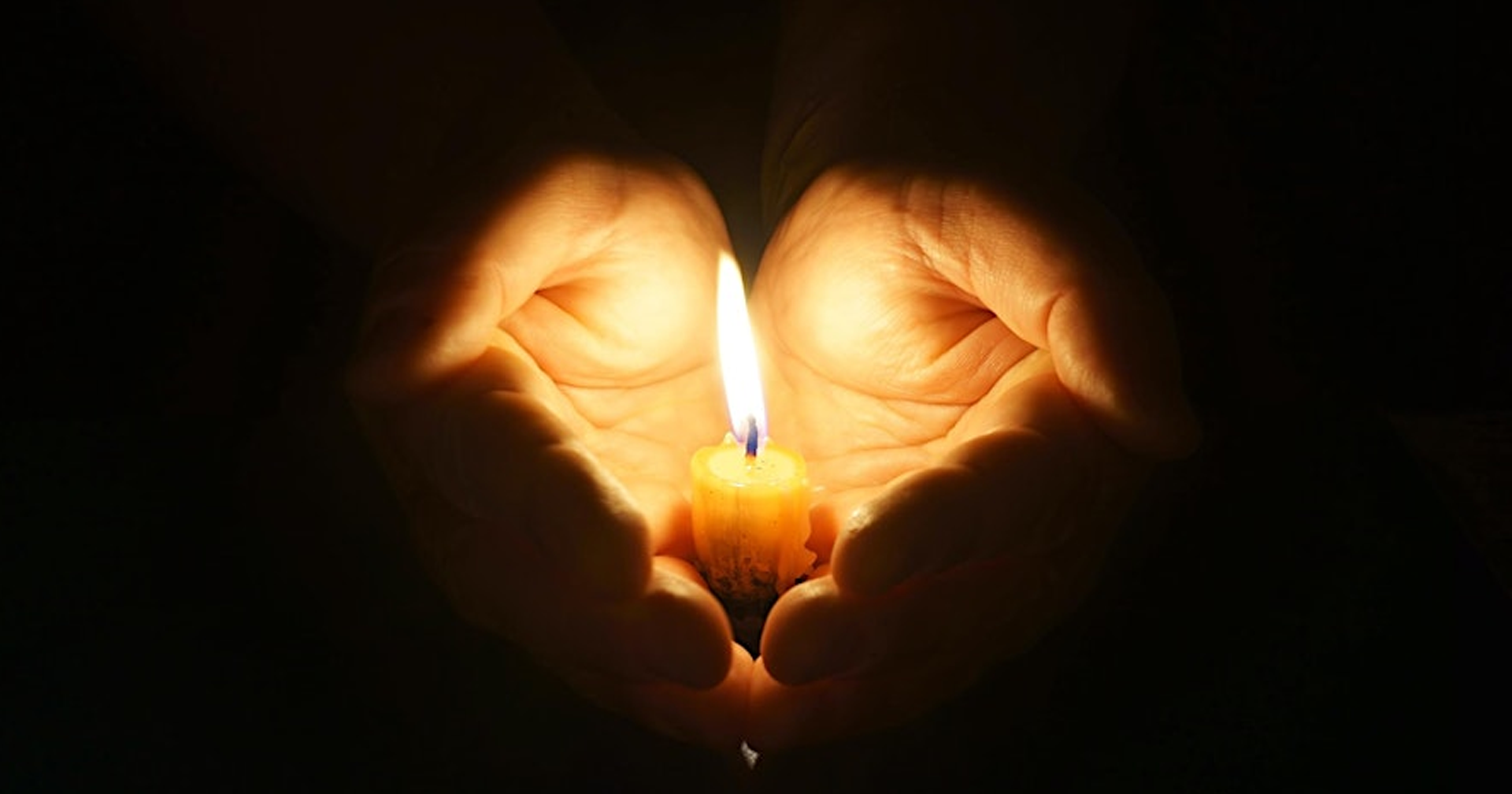 candle cupped in hands